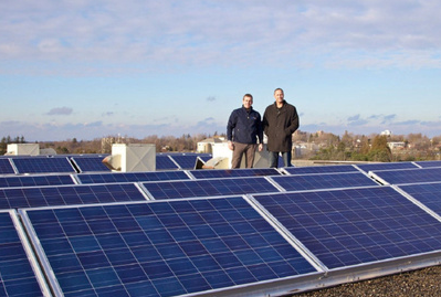 RoyandWillBeardmore Two men stand on a rooftop amongst solar panels